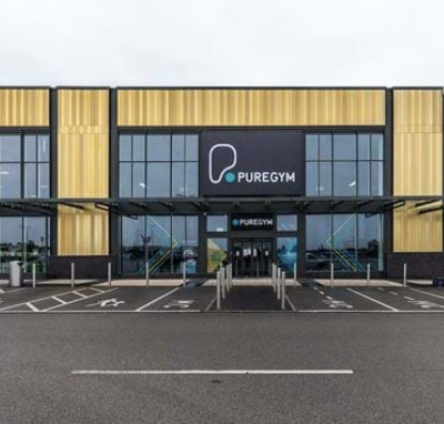 Front view of the new Pure Gym location at Liverpool Shopping Park, featuring a modern exterior with large windows and the Pure Gym logo prominently displayed above the entrance.